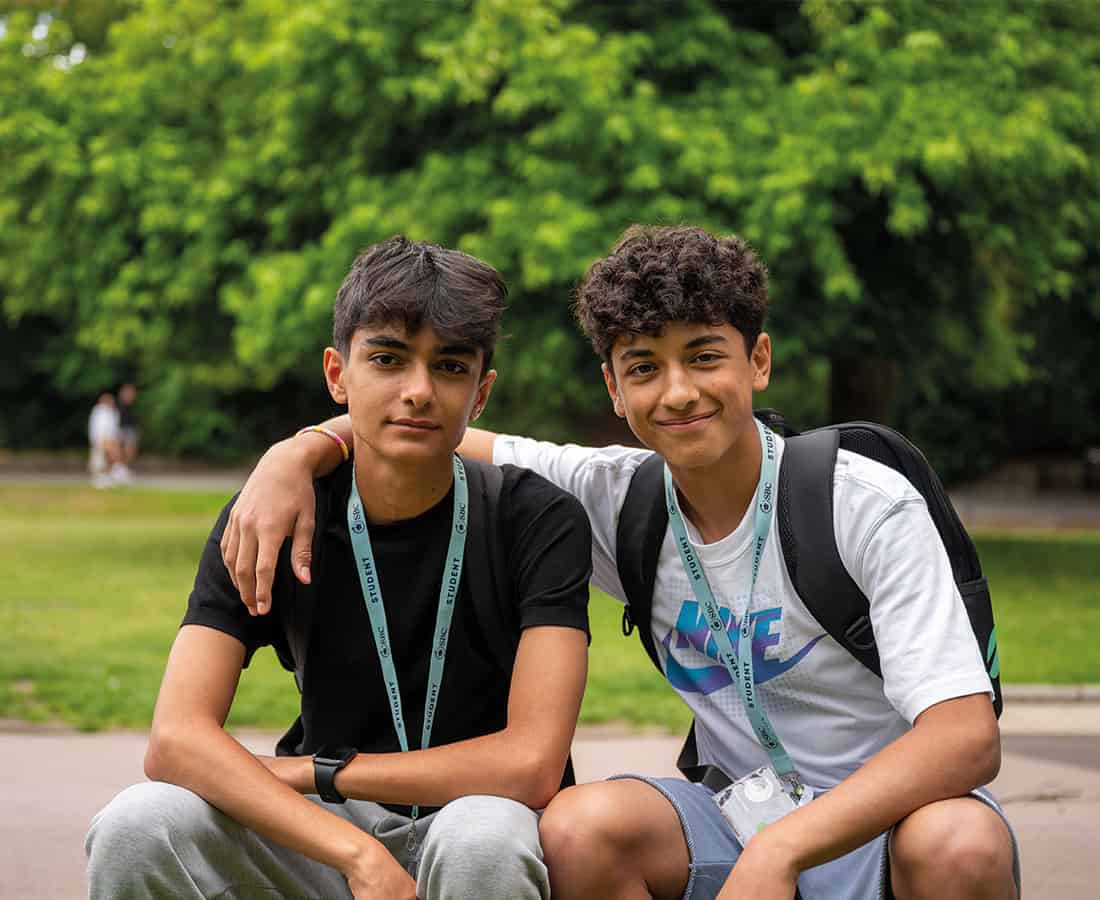 Two summer school students in a London park smiling