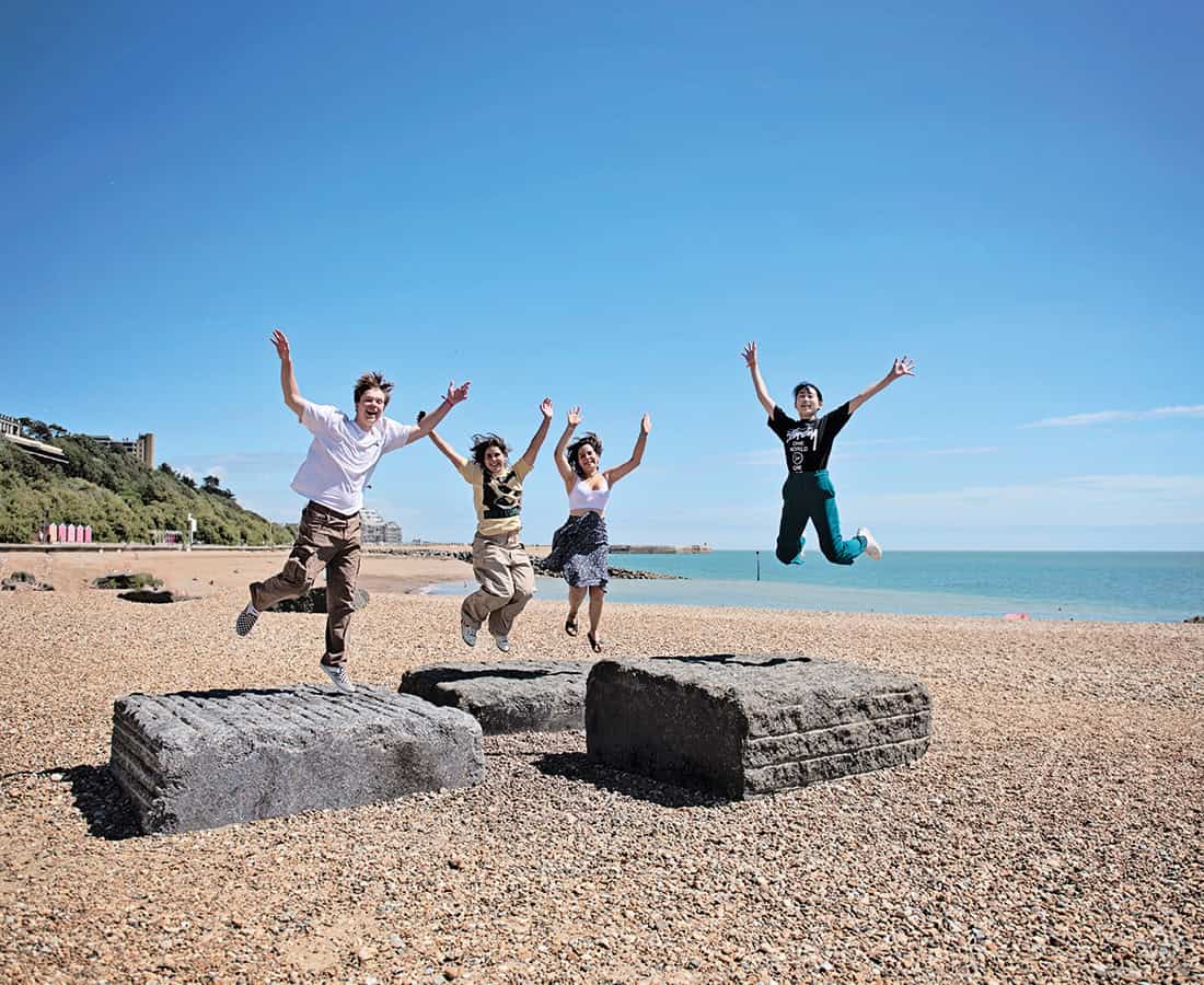 Students jumping at the beech at Earlscliffe Summer School