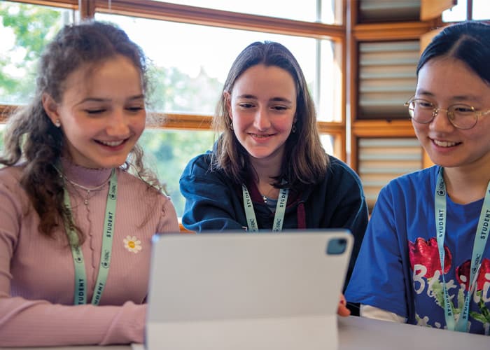 three-smiling-female-students-using-educational-app